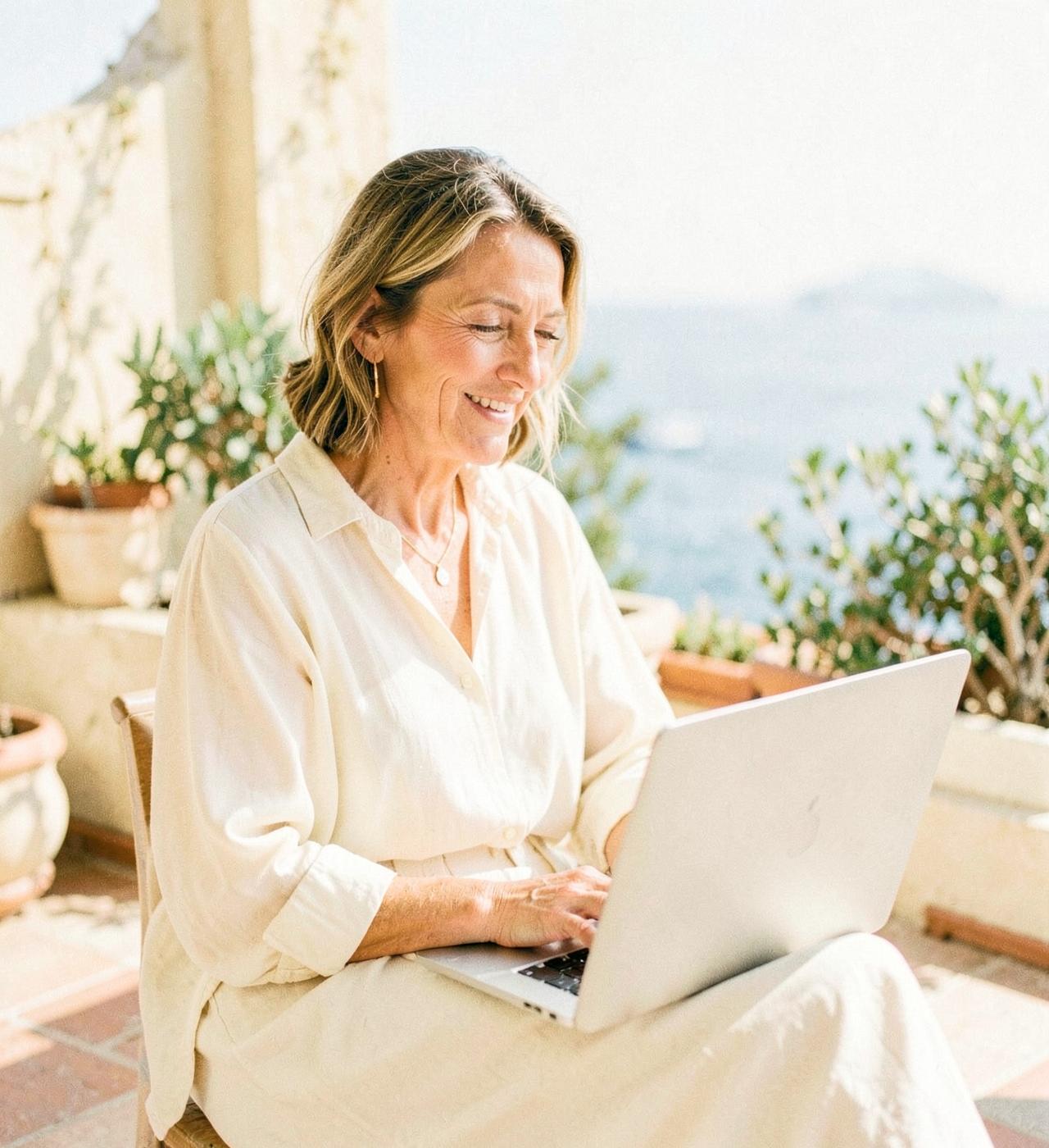 Frau mit Laptop auf einer mediterranen Terrasse